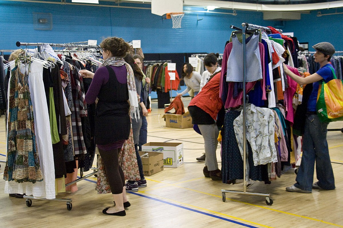 A group of people looking at clothes in a gym.