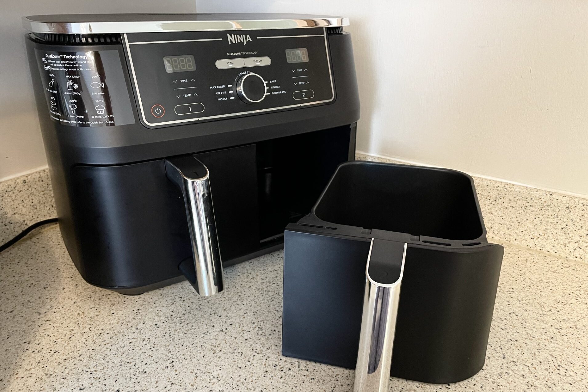 A dual basket air fryer sitting on a counter top.