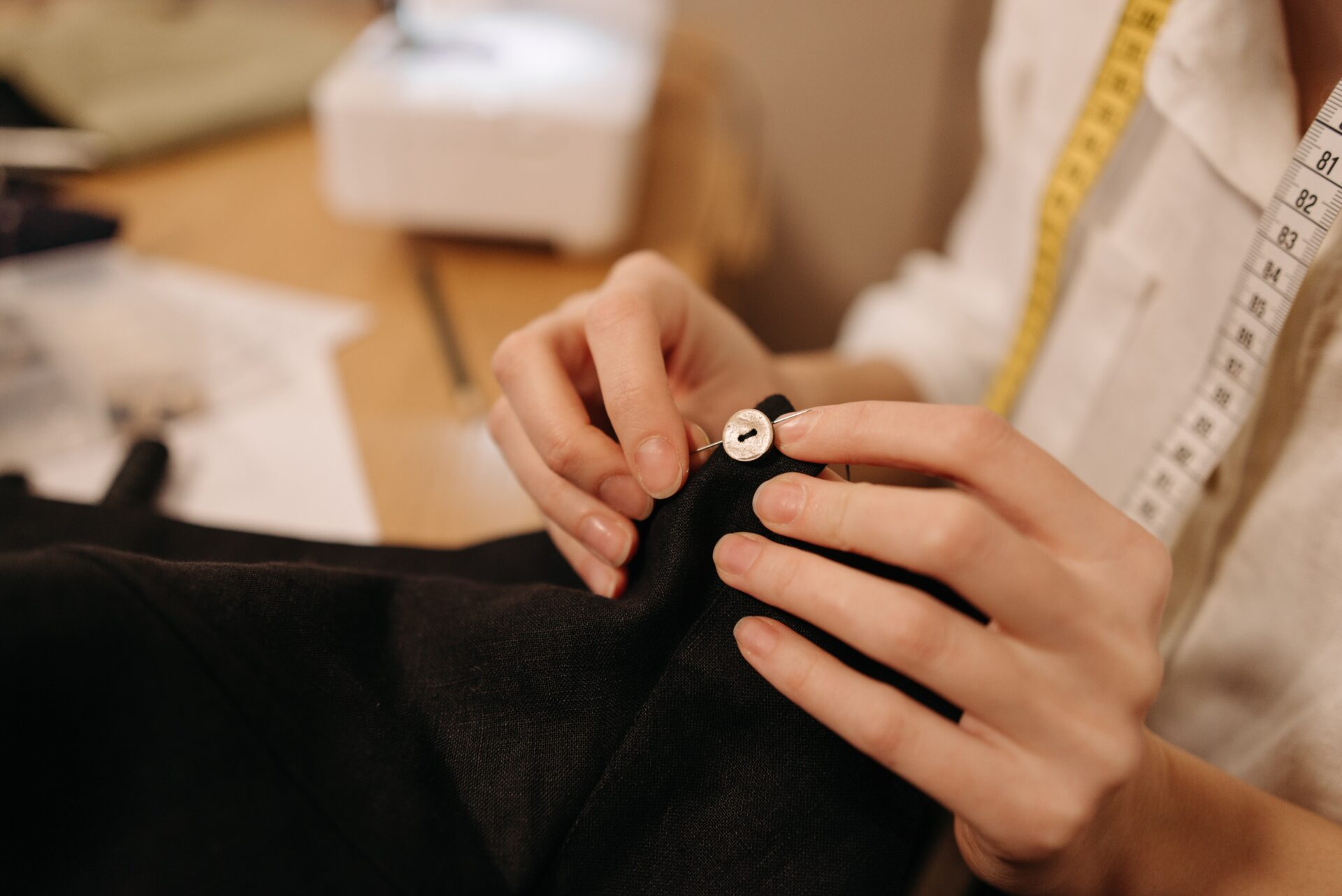 A woman is sewing a button on a shirt.