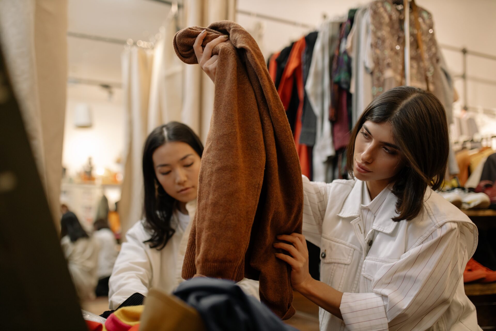 Two women looking at clothes in a clothing store.