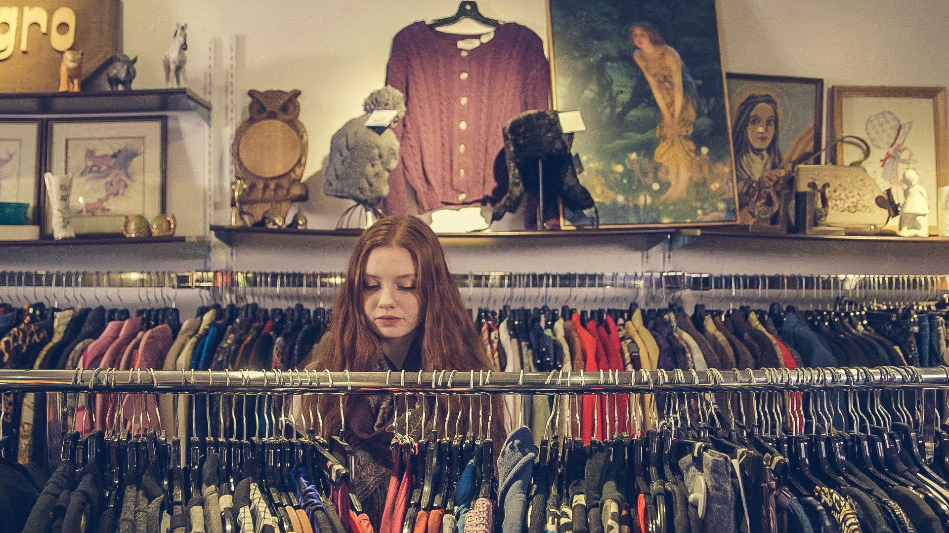 A woman looking at clothes in a clothing store.