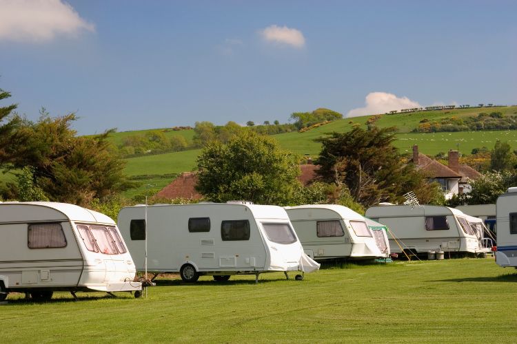 A group of rvs parked on a grassy field.