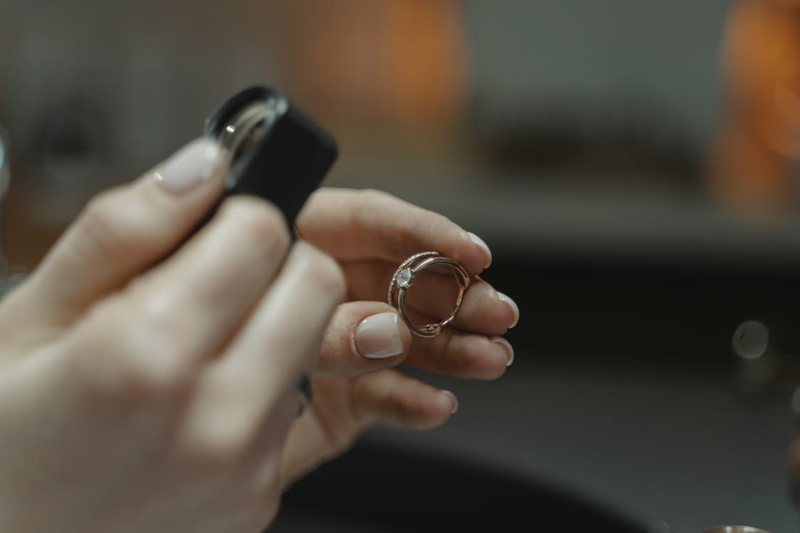 A woman is putting a ring on a finger.