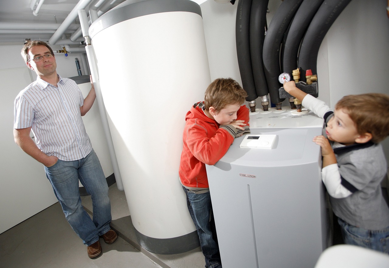 A man and two children standing next to a ground source heat pump, helping them save money.