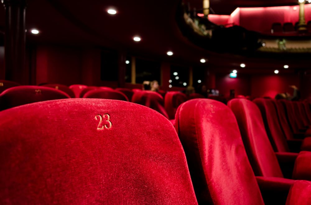 A row of red seats in an auditorium.