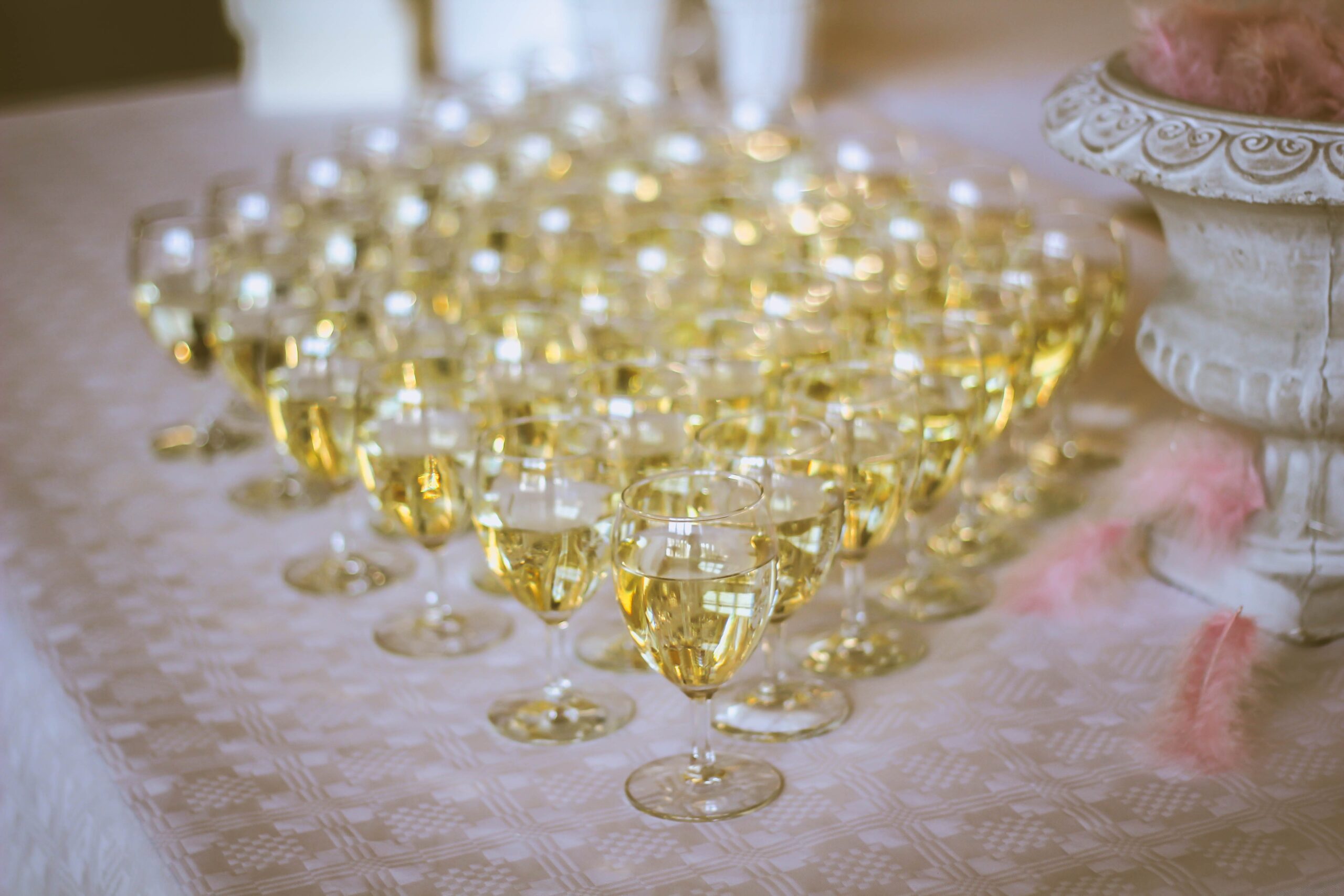 Champagne glasses are lined up on a table for hen party activities.