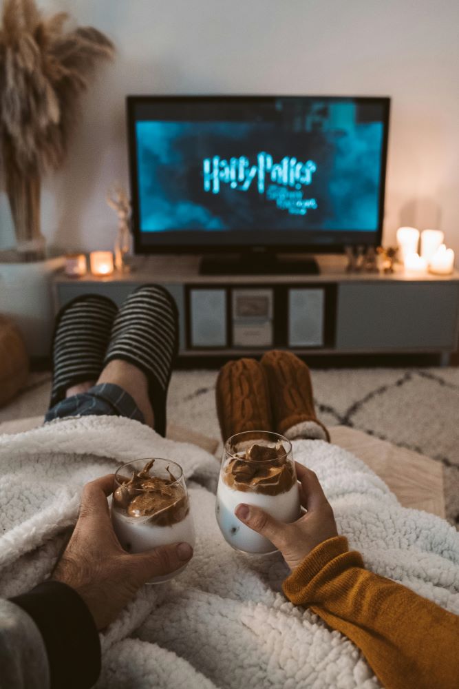 Two people watching harry potter on tv.