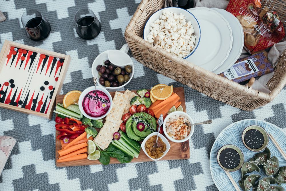 A picnic basket with food and drinks on it.