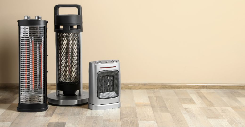 Three electric heaters on a wooden floor.