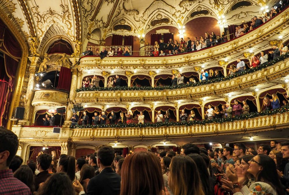 A crowd of people in an ornate theater.