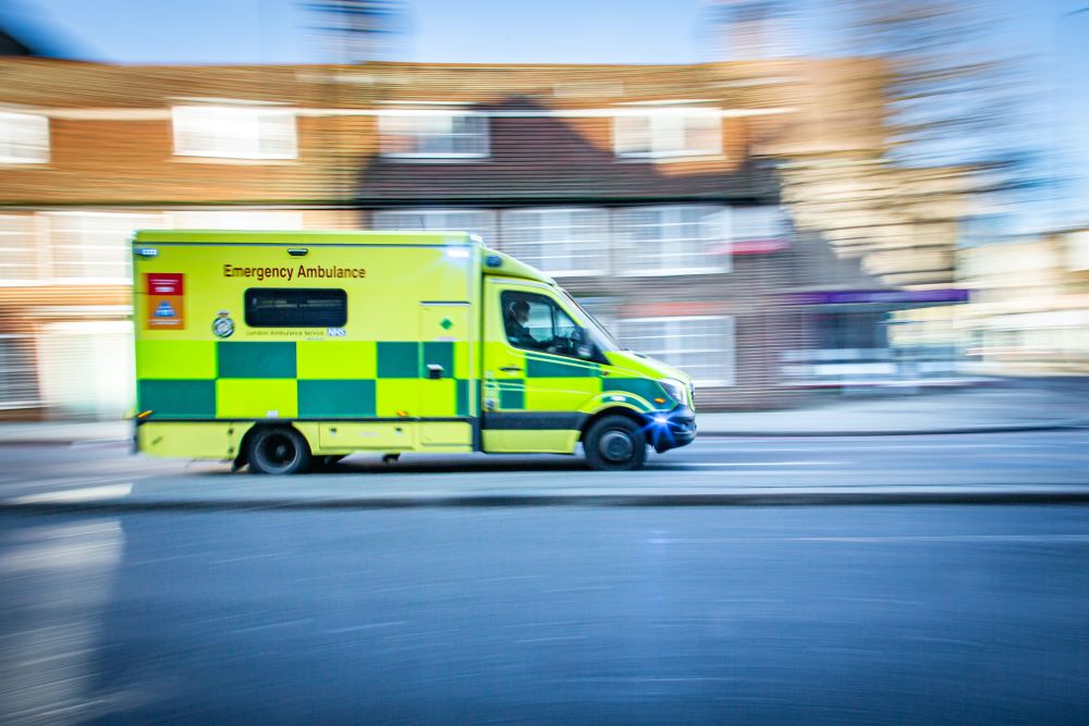 A blurry image of an ambulance driving down a street.