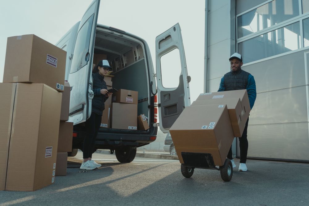 Two men loading boxes into a van.