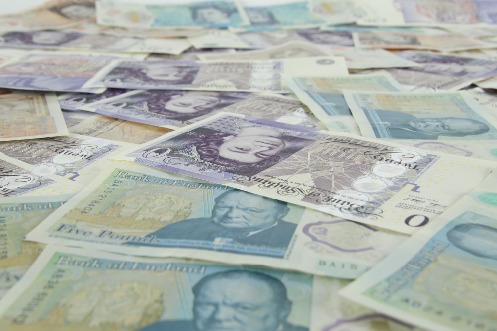 A pile of british banknotes on a white background.