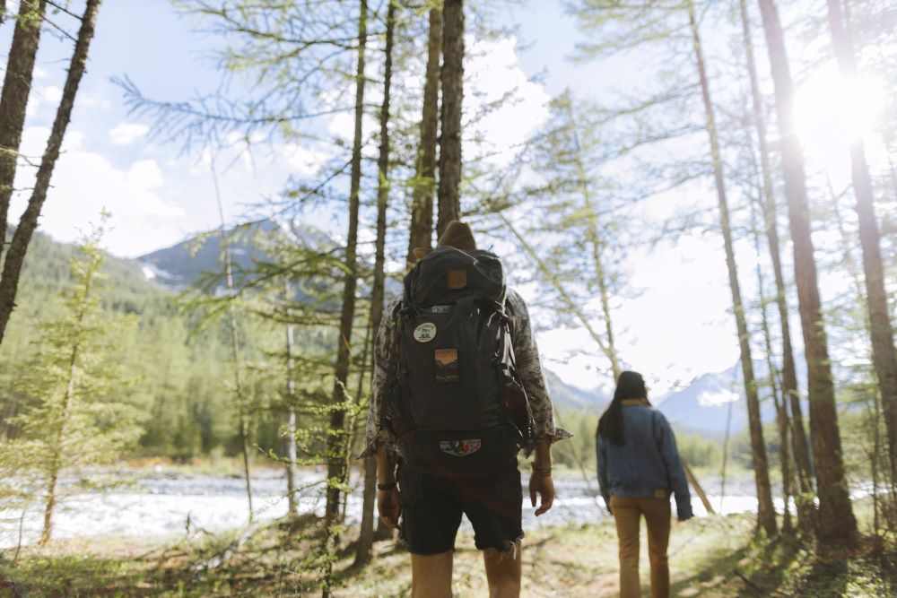 A man with a backpack walking in a forest.