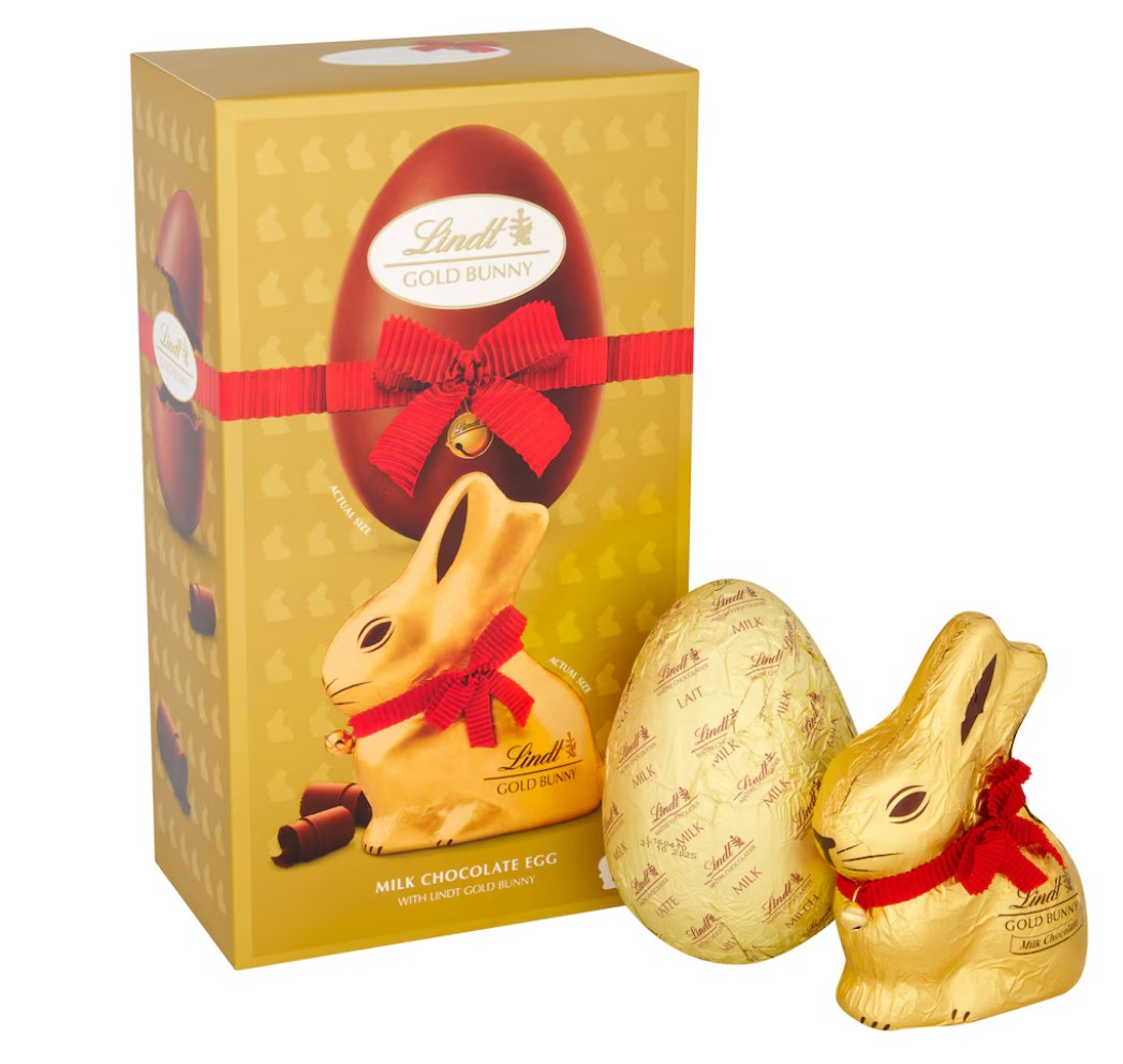 Lindt gold bunny Easter egg A Lindt Gold Bunny milk chocolate egg with a chocolate bunny, both wrapped in gold foil with red ribbons, displayed beside a matching gold box.