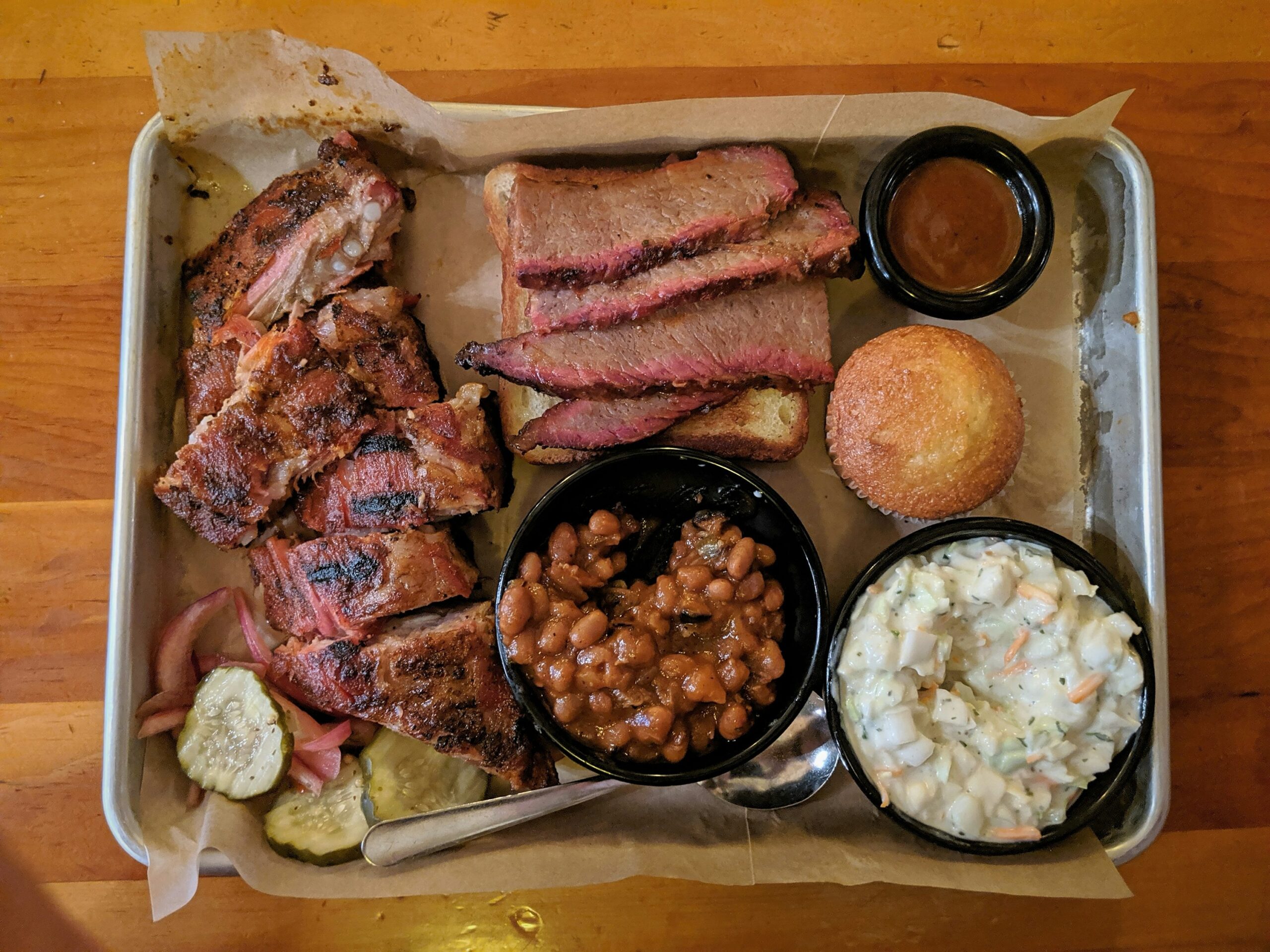 Barbecue sides An image showing cheap BBQ ideas for sides alongside meat, such as beans, barbecue sauce, and grilled veggies