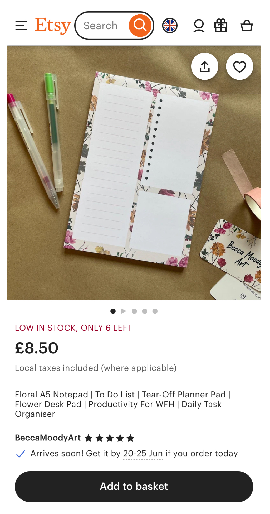A floral A5 notepad with perforated tear-off sheets, two pens, and business cards on a desk; Etsy product listing displays price and low stock notice.