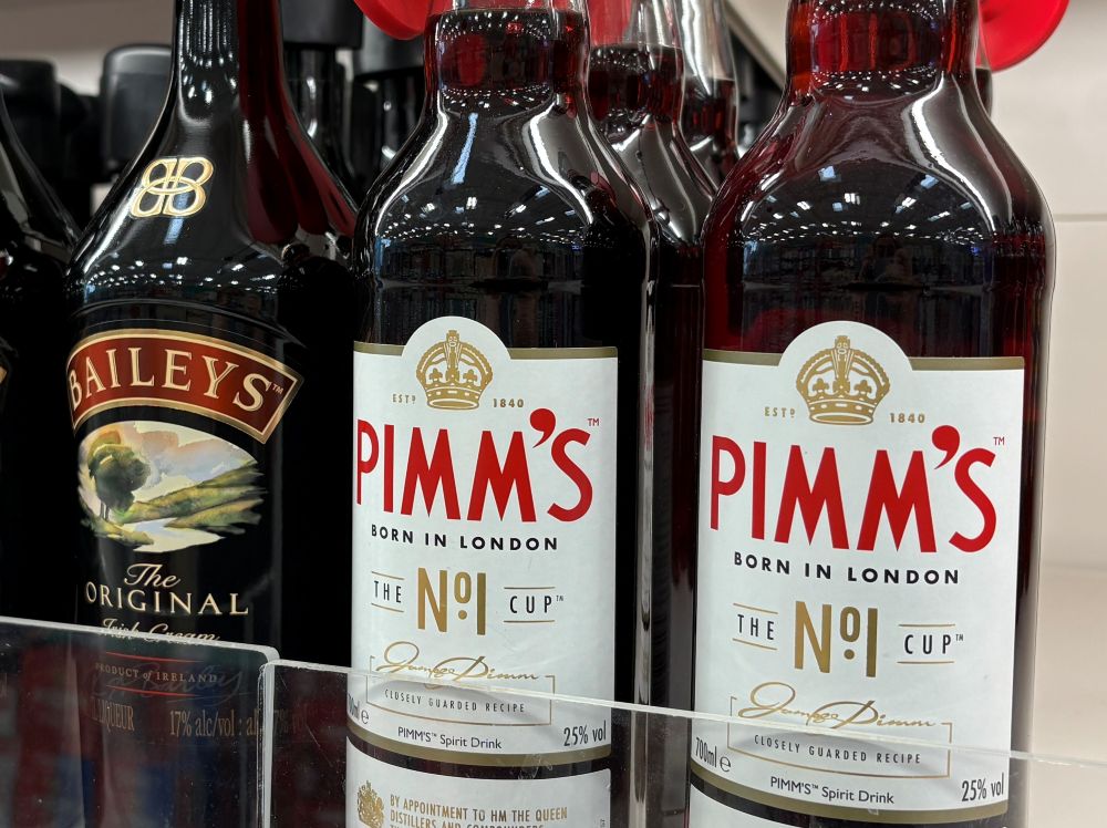 Bottles of Baileys Irish Cream and Pimm’s No. 1 Cup displayed on a store shelf.