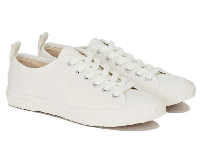 A pair of white canvas sneakers with laces, metal eyelets, and pull tabs at the heel, shown on a plain background.