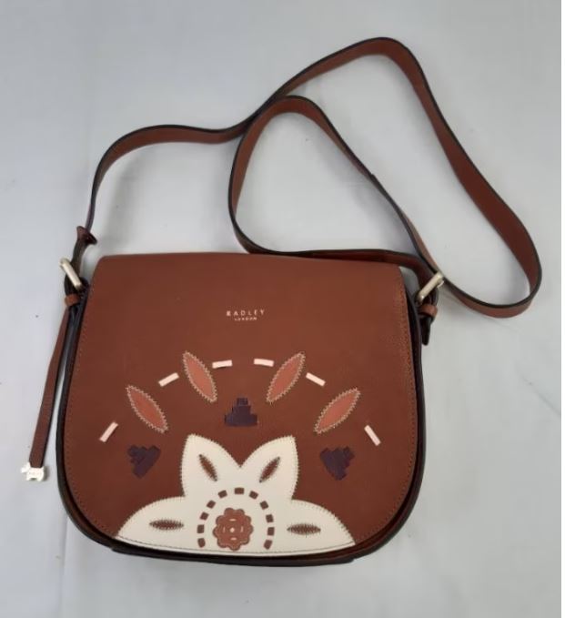 Brown leather crossbody bag with a floral and leaf pattern on the front flap, featuring a long adjustable strap and "Radley London" logo.