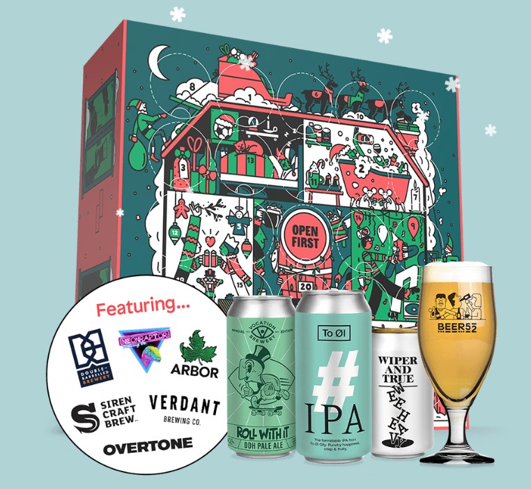 A festive craft beer advent calendar box with illustrated holiday design, five different beer cans, a beer glass, and a featured breweries sticker in front.