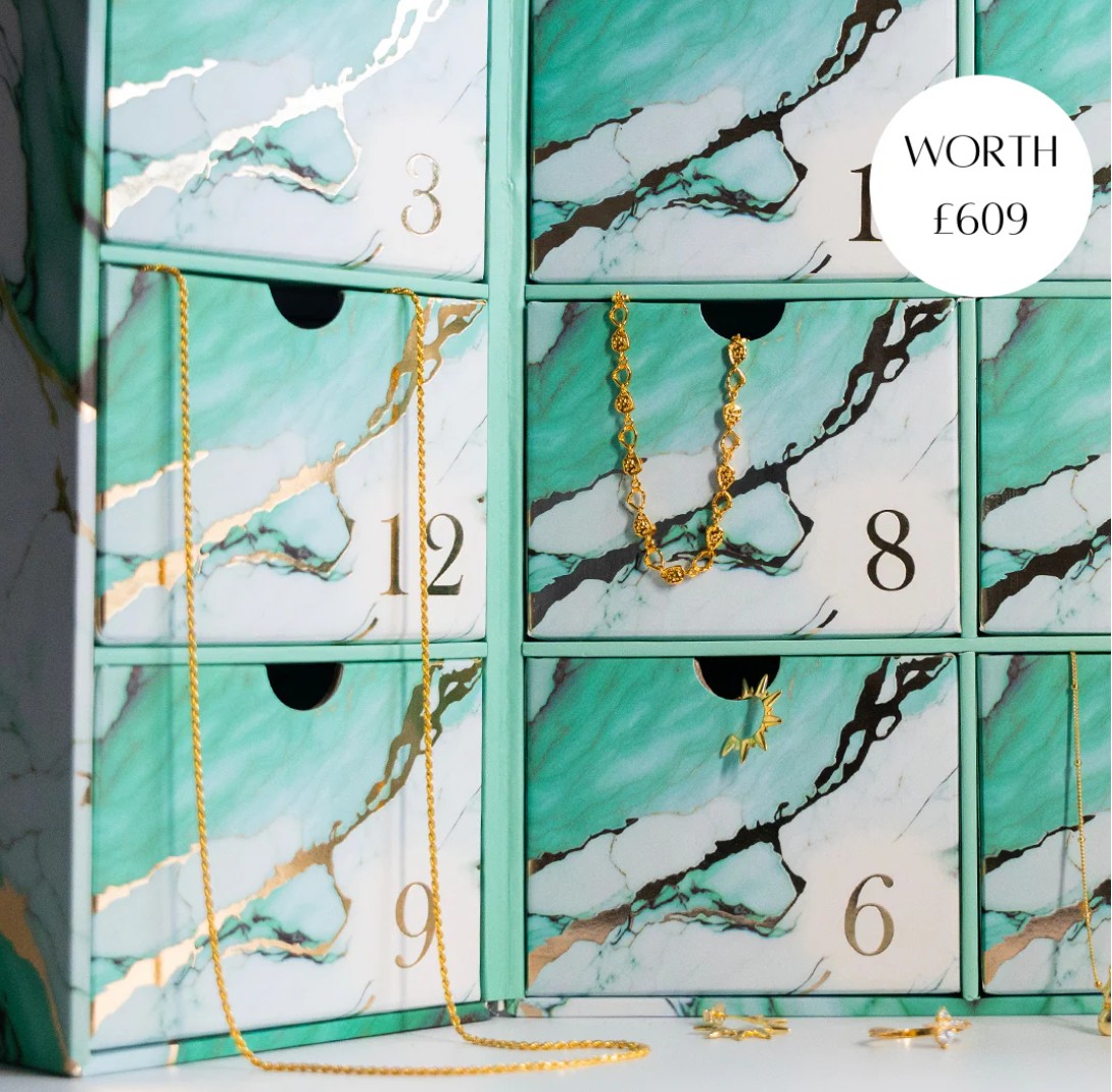 Grove & Vae Jewellery Advent Calendar 2025 A marble-patterned jewelry advent calendar with numbered drawers, some open to reveal gold jewelry; a circle reads "WORTH £609".