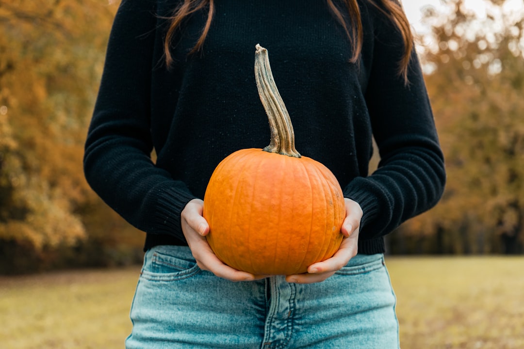 Photo by Taylor Cole a woman holding a pumpkin