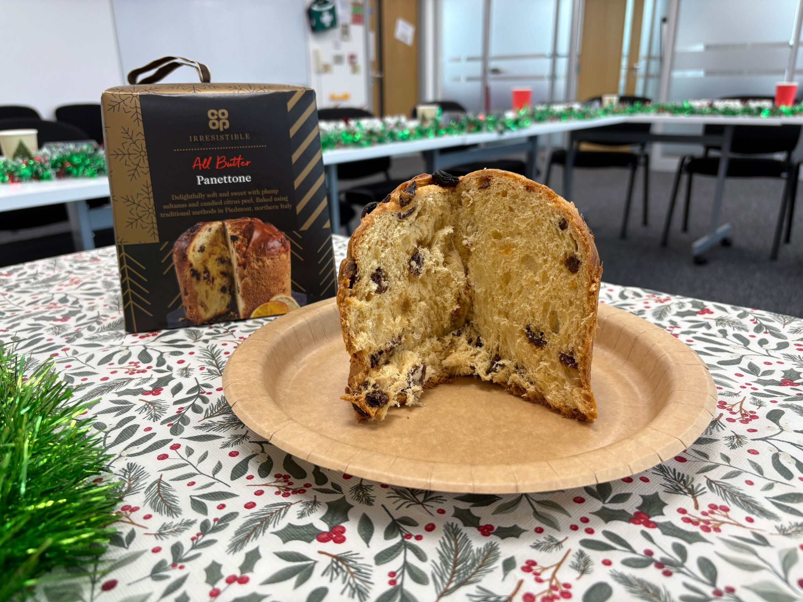 A Co-op Panettone sitting on a brown plate in front of its box
