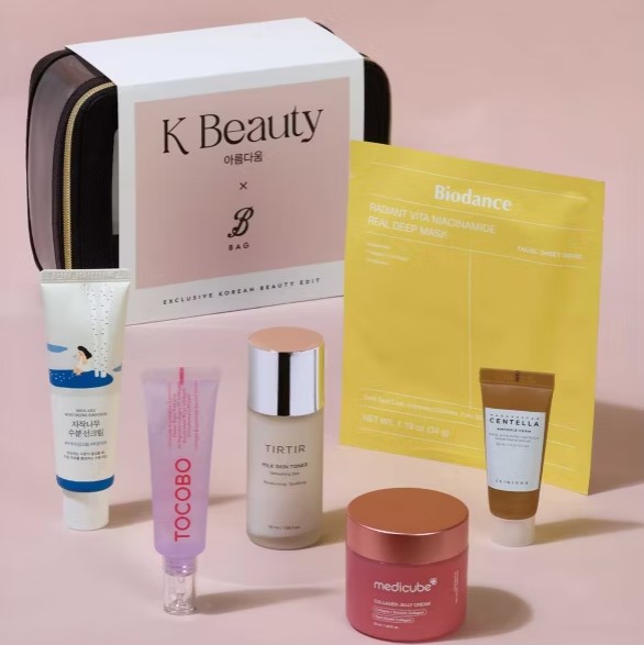 A collection of Korean beauty products displayed with a beige and black cosmetic bag, including creams, serums, a face mask, and tubes in various colors.