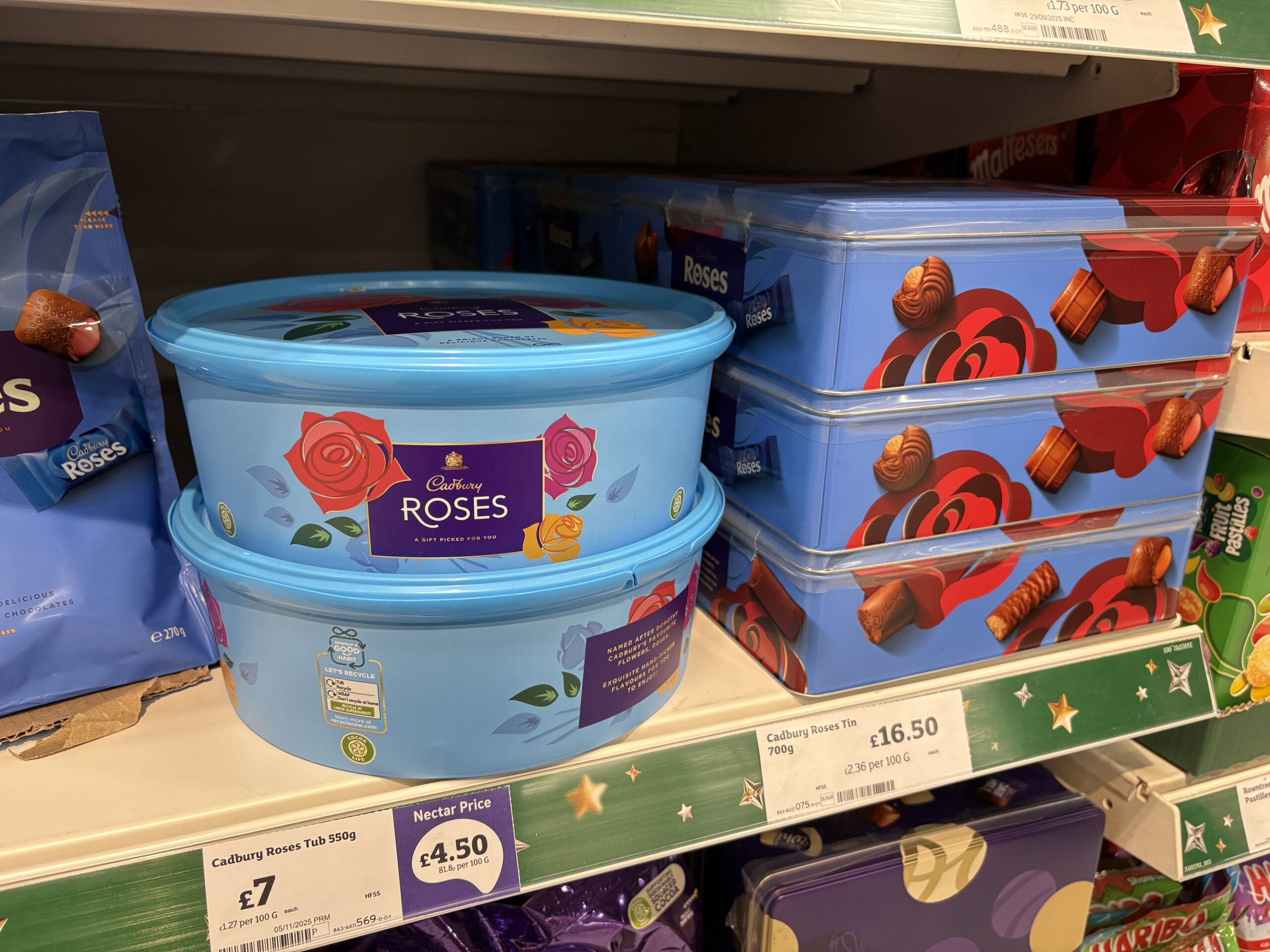 An image showing Cadbury Roses tubs of supermarket chocolates on shelves