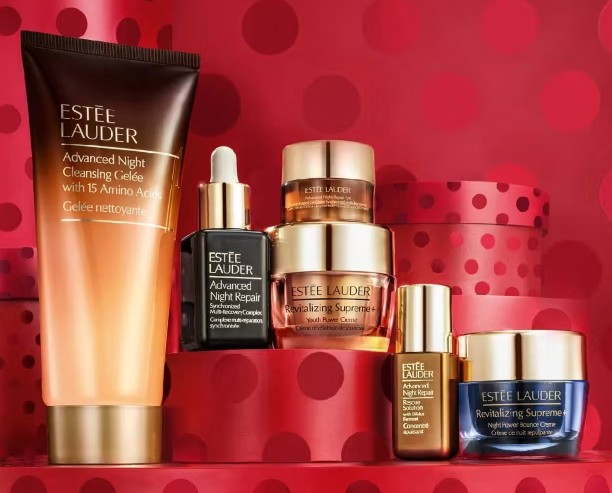 Estée Lauder Skincare Superstars Beauty Of The Night Gift Set A set of Estée Lauder skincare products, including creams, serums, and a cleansing gel, arranged against a red background with dots.