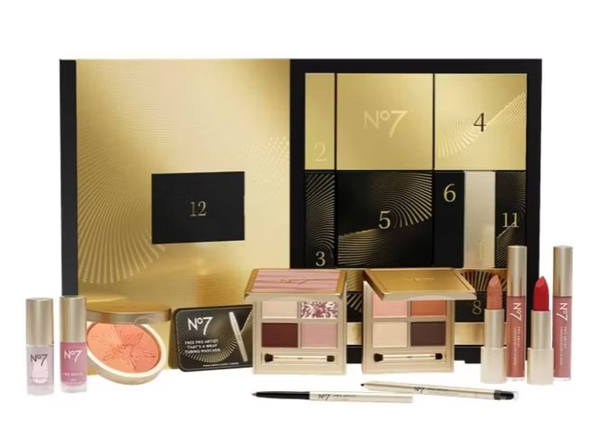 no7 star gift A No7 makeup gift set with an open gold and black box revealing numbered compartments and assorted makeup products arranged in front.