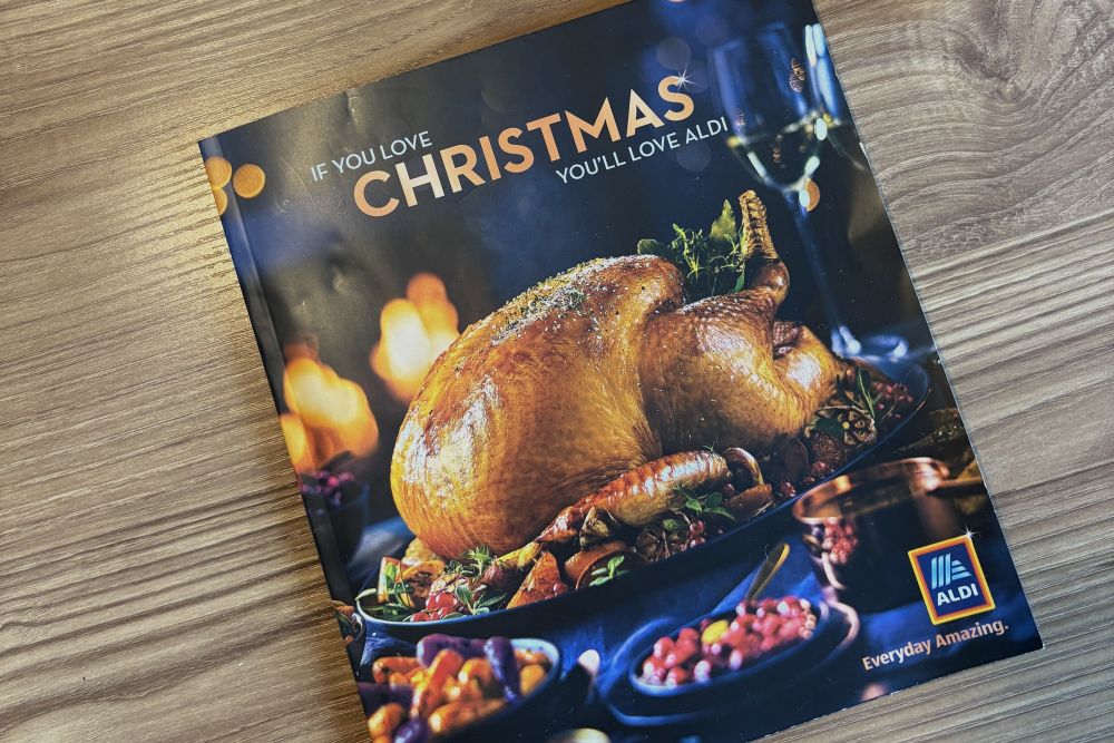 aldi christmas catalogue 2025 Aldi holiday brochure on a wooden surface featuring a roasted turkey with side dishes and the text "If you love Christmas, you'll love Aldi.