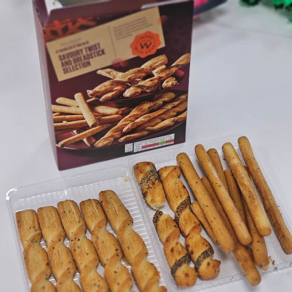tcb waitrose christmas savoury twist and breadstick selection 2 An open box of assorted breadsticks with three types of breadsticks arranged in a plastic tray on a white surface.