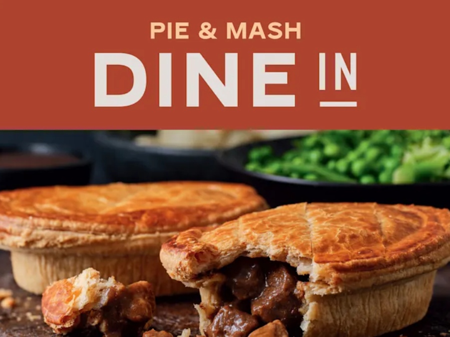 M&S Pie and Mash Dine-In Two meat pies on a wooden surface, one pie partially eaten to show the filling, with green peas in the background. Text above reads "PIE & MASH DINE IN.