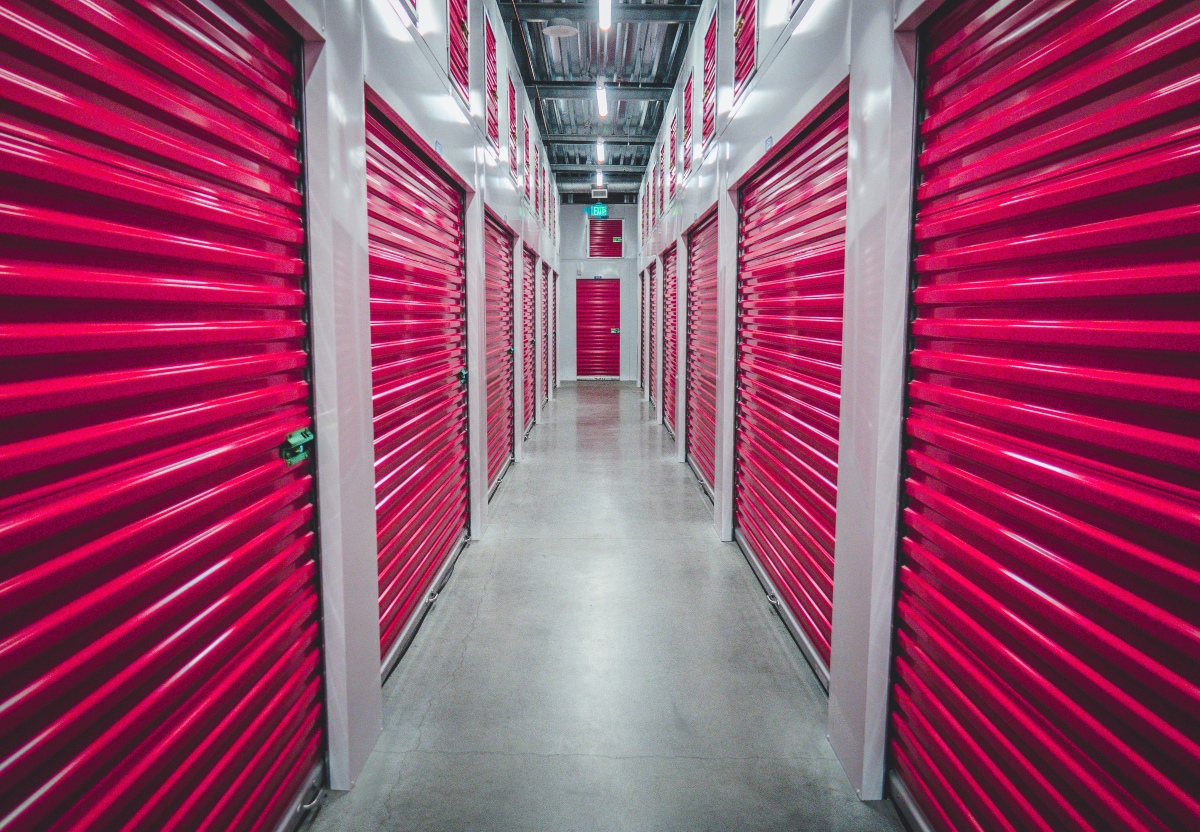 A hallway in a facility for storage auctions, showing lockers full of second-hand goods