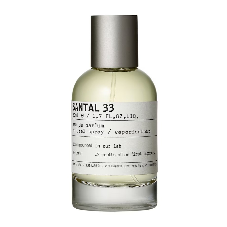 A clear glass bottle of Le Labo Santal 33 eau de parfum with a silver cap and a white label displaying product details.