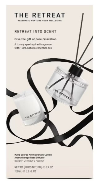 the retreat candle set A box labeled "The Retreat" displays a hand-poured aromatherapy candle and reed diffuser with black ribbon accents and minimalist design elements.