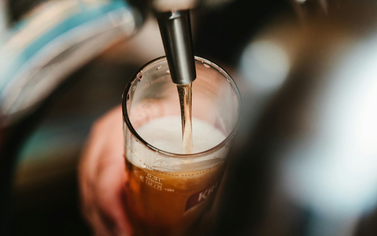 An image showing a pint glass being filled with beer from a beer tap