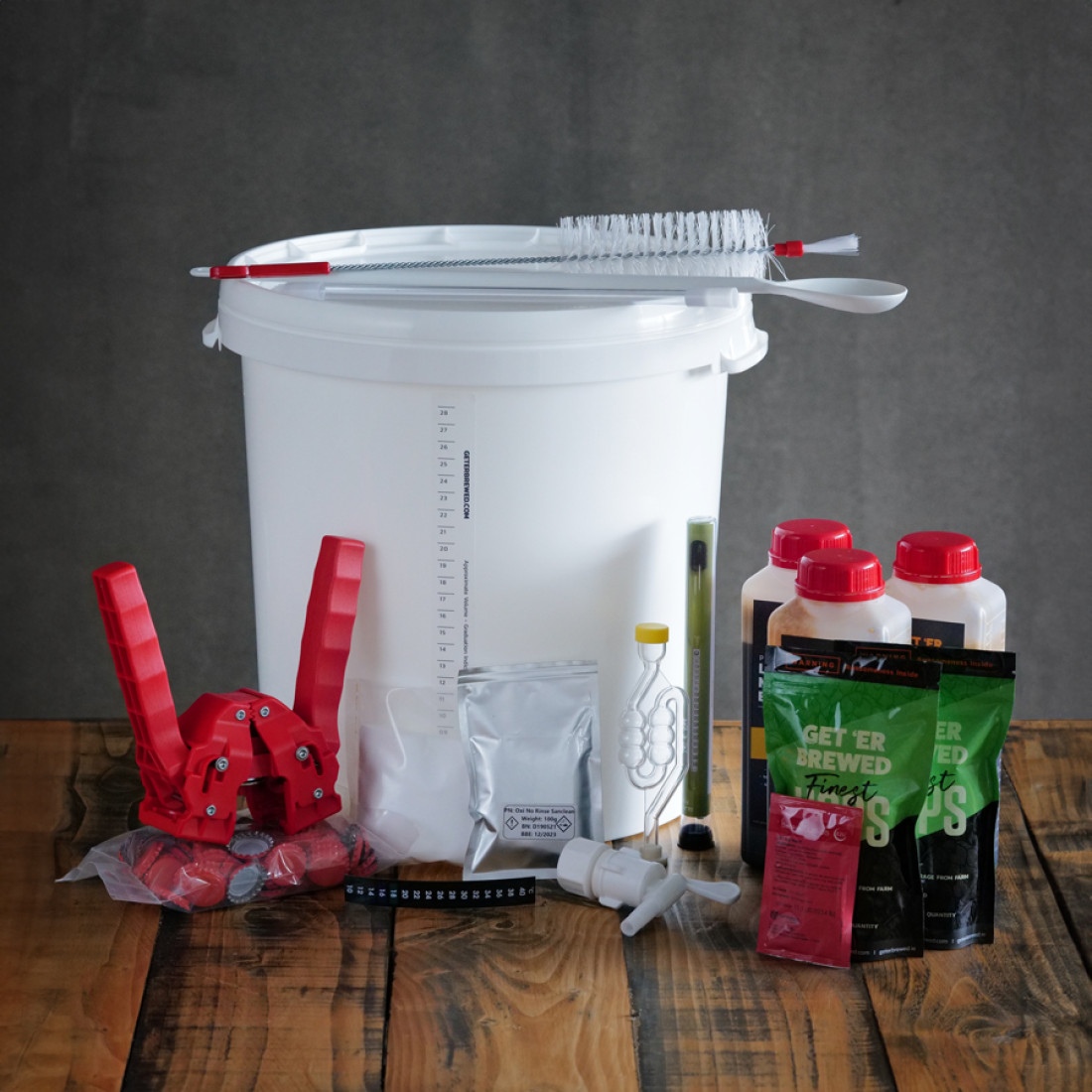 A Geterbrewed homebrewing beer kit, including a fermentation vessel, malt, yeast, hops, a bottle capper, and more
