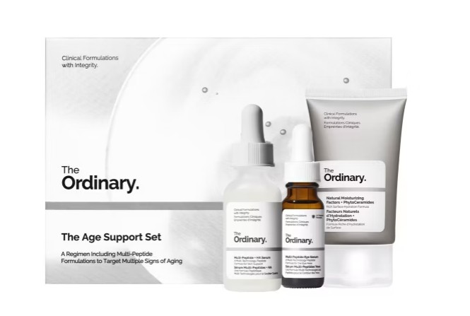 The Ordinary Age Support Set includes a serum dropper bottle, a smaller bottle, and a tube, displayed in front of the product packaging box.