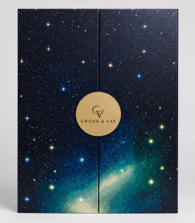 A rectangular box with a starry night sky design and a gold circle label reading “Grove & Vae” at the centre where the box doors meet.
