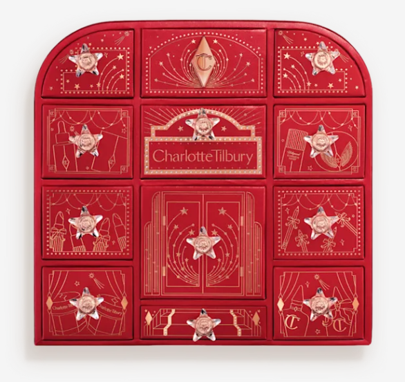 charlottes hollywood beauty wonderland advent calendar Red Charlotte Tilbury advent calendar box with twelve gold-decorated drawers, each featuring a star-shaped rose gold knob and festive illustrations.