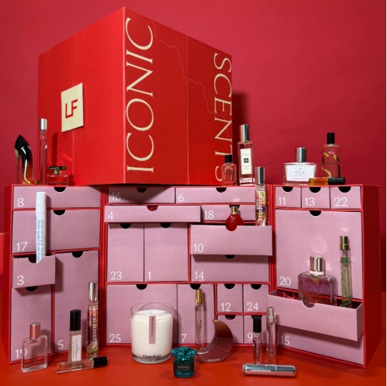 lookfantastic 2026 fragrance advent calendar.png Red and pink advent calendar box with numbered drawers, each open to reveal perfumes, cosmetics, and beauty products, against a solid red background.