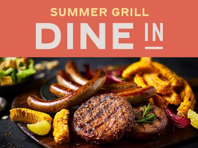 Grilled sausages, burger patties, corn, potato wedges, and salad on a wooden board with the text “SUMMER GRILL DINE IN” above.