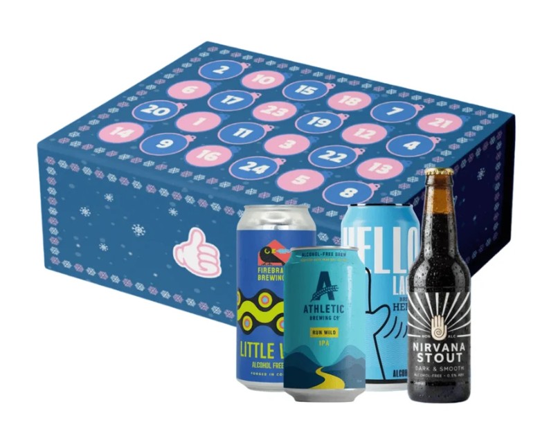 wise bartender 2026 alcohol free beer advent calendar A blue advent calendar box with numbered doors is shown behind three alcohol-free beer cans and one bottle, each with distinct colourful labels.