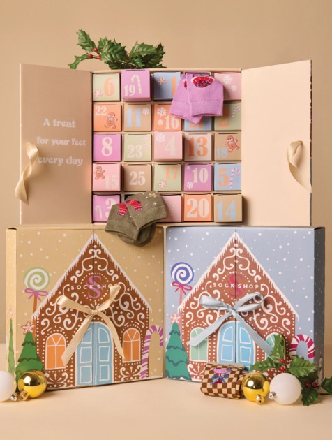 bamboo Advent calendar styled as gingerbread houses with numbered drawers, holiday decorations, and pairs of festive socks displayed on top and inside the calendar.