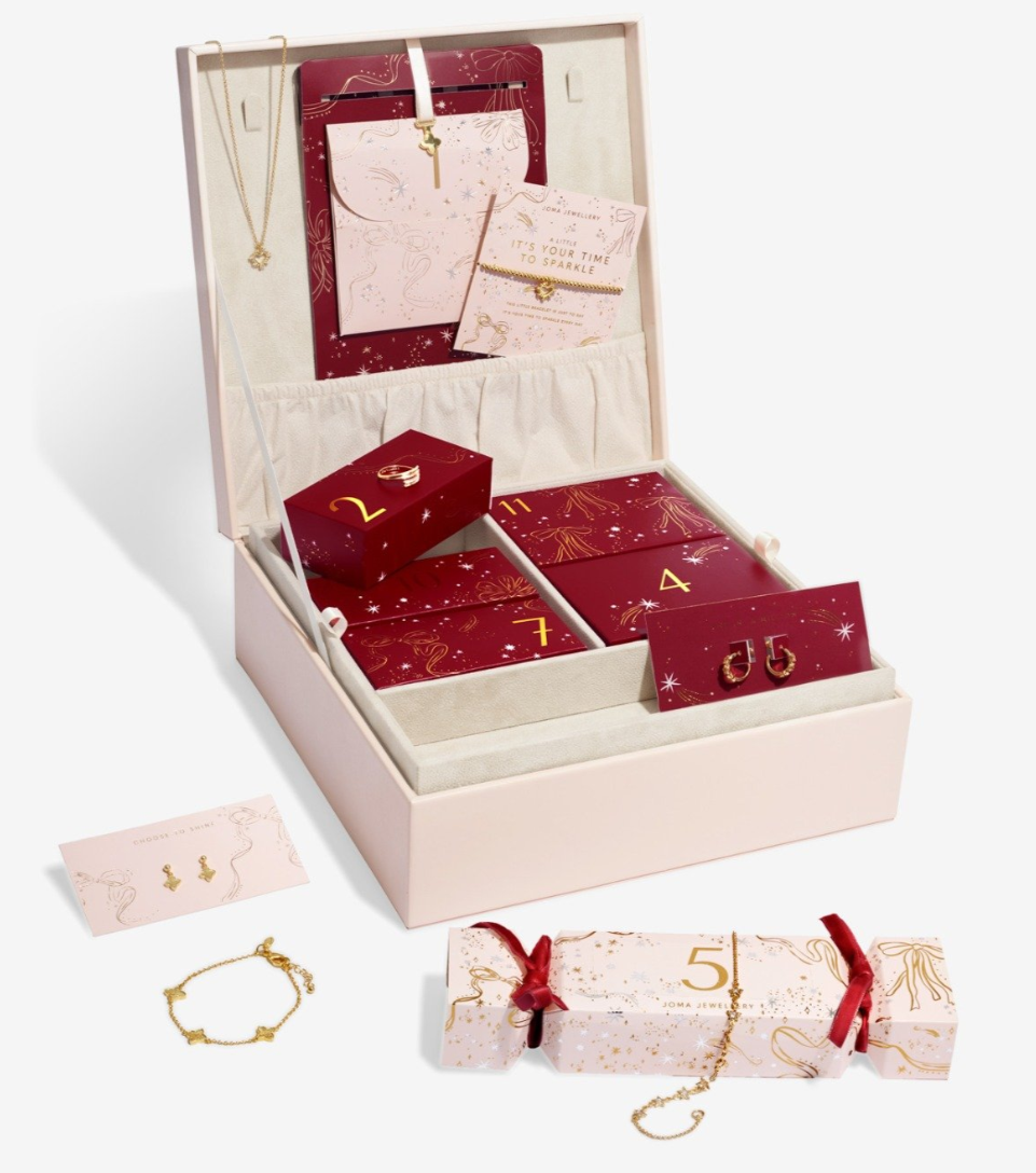 A jewellery advent calendar box with numbered compartments, gold jewellery pieces including earrings, a necklace, a bracelet, and festive packaging, all arranged on a white background.