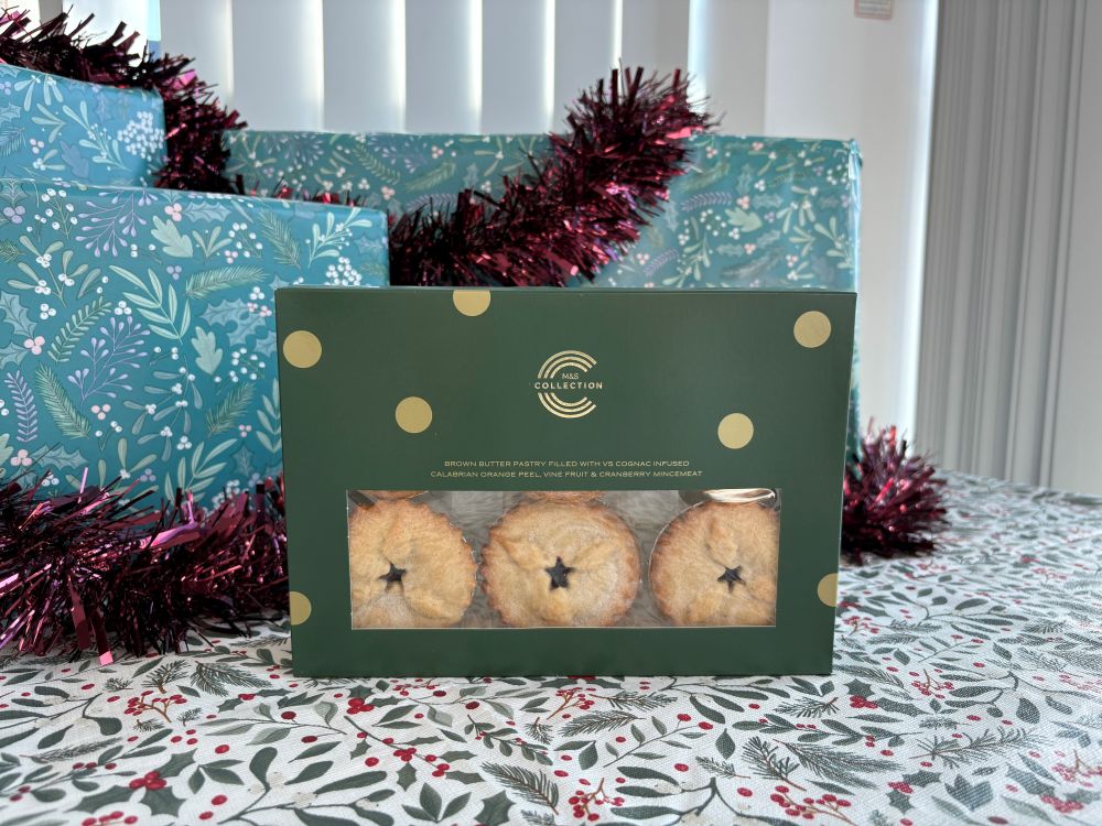 M&S Collection mince pie box with a window displaying three star-topped mince pies, set against festive gift wrap.